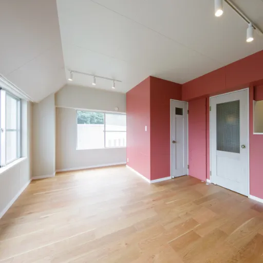 写真：フローリングの床とピンク、白に塗り分けられた壁