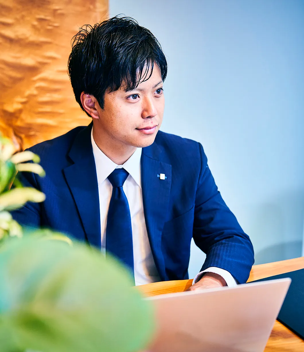 写真：社内の席についてノートパソコンを操作している