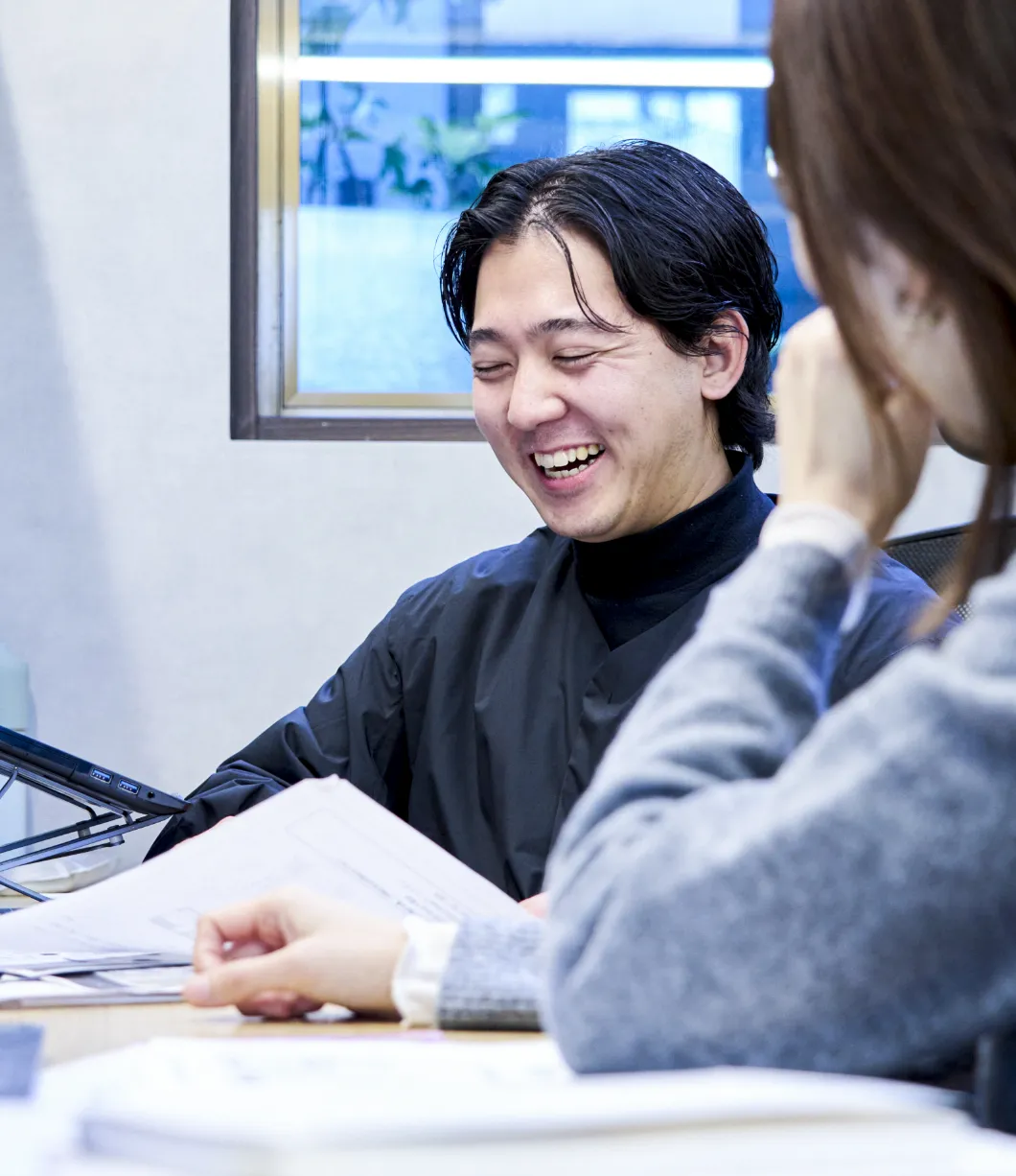写真：書類を開きながら笑顔で打ち合わせをしている様子